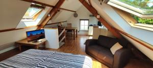 a room with a bed and a couch in a attic at Logies op Dreef in Driebergen