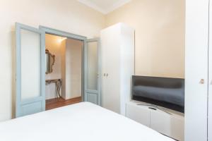 a bedroom with a bed and a flat screen tv at Suite Cavour by iCasamia in Varese