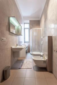 a bathroom with a sink and a toilet and a mirror at Suite Cavour by iCasamia in Varese