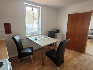 een eetkamer met een tafel en stoelen en een raam bij Ferienwohnung - Stein - in Rollshausen