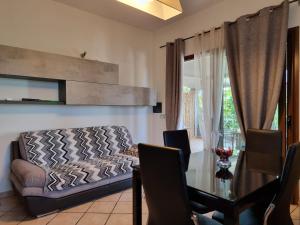 een woonkamer met een bank en een glazen tafel bij LEO'S HOUSE in Budoni