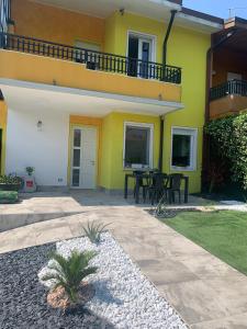 a yellow and white house with a patio at Casa Dai Angioi in Sirmione