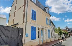 un bâtiment avec des portes bleues et une clôture dans une rue dans l'établissement Lovely Home In Deauville With Wifi, à Deauville