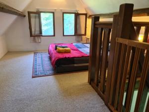 - une chambre avec un lit et une couette rouge dans l'établissement Petite Maison de campagne, à Fauguernon
