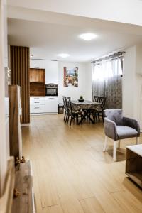 a kitchen and living room with a table and chairs at Apartment Neiv in Tivat +4 photos