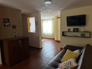 ein Wohnzimmer mit einem Sofa und einem Flachbild-TV in der Unterkunft casa amplia y económica in Villa de Leyva