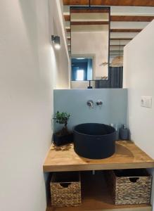 baño con lavabo negro y espejo en Arhodiko Studios en Astipalea