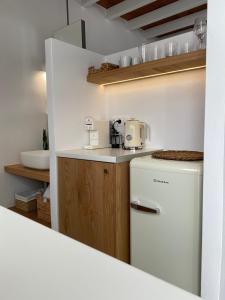 a kitchen with a white refrigerator and a sink at Arhodiko Studios in Astypalaia