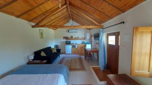 um quarto com uma cama e uma sala de estar em The Cottage near the lake em Pedrógão Grande