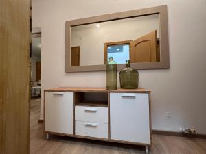 a dressing table with a mirror and a bottle on it at SOMMERHAUS JOSEFA in Mühldorf