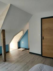 Camera mansardata con letto e porta in legno. di La maison du Passeur a Fillé