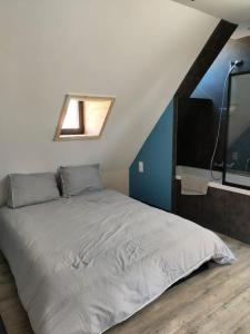 1 dormitorio con 1 cama grande y ventana en La maison du Passeur, en Fillé