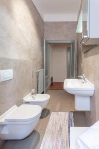 a bathroom with two sinks and two toilets at Suite Cavour by iCasamia in Varese