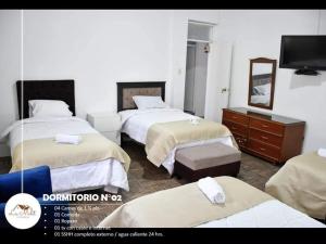 Habitación de hotel con 3 camas y TV. en Hospedaje La Melit en Tacna