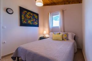 a bedroom with a bed and a clock on the wall at Little Artemis Cozy Cottage in Argos +42 photos