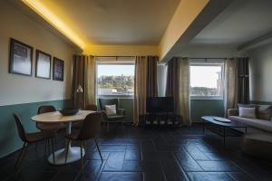 sala de estar con mesa y sofá en Elite Ermou Suites, en Atenas