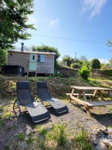 a picnic table and two chairs and a picnic table and a bench at Apple Hut in Torquay