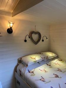a bedroom with a bed with a heart on the wall at Apple Hut in Torquay