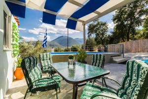 a patio with a table and chairs and a pool at Little Artemis Cozy Cottage in Argos