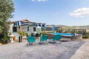 a patio with chairs and a swimming pool at Little Artemis Cozy Cottage in Argos