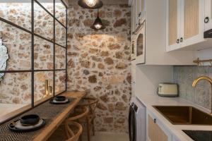 una pequeña cocina con mesa de madera y fregadero en il Campanile Luxury Living, en La Canea