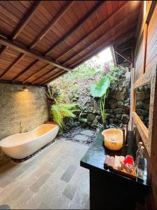 un bagno con vasca e lavandino di Aix Cottage Ubud ad Ubud