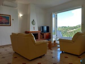 a living room with two chairs and a television at Villetta Panoramica in Ischia