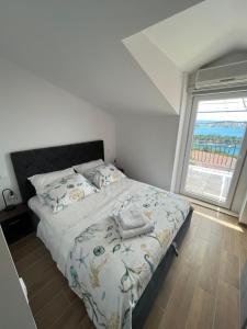 a bedroom with a bed and a large window at Calypso in Trogir