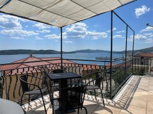 a table and chairs on a balcony with a view of the water at Calypso in Trogir