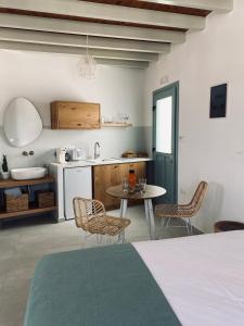 uma cozinha com mesa e cadeiras num quarto em Arhodiko Studios em Astypalaia