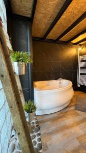 a bathroom with a bath tub and potted plants at LOFT - Jardin des Plantes in Rouen