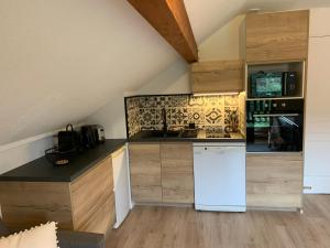 eine Küche mit einem weißen Kühlschrank und einem Herd in der Unterkunft Le Flocon d'Aurouze 522, Appartement 4 personnes, La Joue du Loup in La Joue du Loup + 35 Fotos