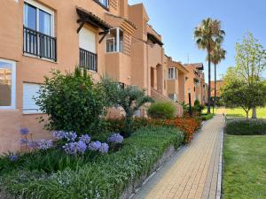 een bakstenen stoep voor een gebouw met bloemen bij Tropical chic in Casares