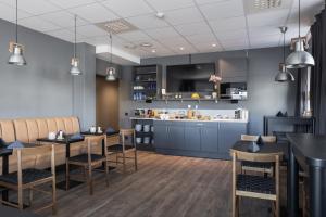 a restaurant with tables and chairs and a bar at Hotell Leksand in Leksand