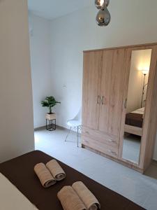 a bedroom with a large wooden cabinet with two towels on a bed at Apartman Polegubic in Biograd na Moru