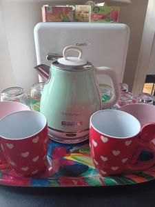 馬里納·迪·比薩的住宿－Affreschi sul mare，茶壶和桌子上的两个杯子