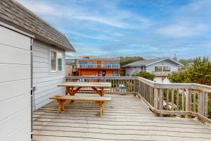 a wooden deck with a picnic table on it at Friend-Ship in Rockaway Beach