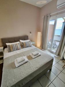 una camera da letto con un grande letto con due asciugamani di Nereides Apartments ad Agios Gordios