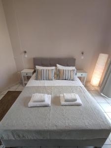 a bedroom with a large bed with two towels on it at Nereides Apartments in Agios Gordios