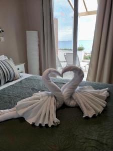 due cigni che fanno un cuore su un letto di Nereides Apartments ad Agios Gordios