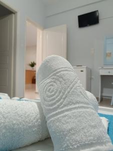 un rotolo di asciugamani bianchi seduti su un divano di ΑΥΡΑ Ενοικιαζόμενα Δωμάτια - AVRA Rooms To Let a Galissas