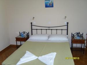a bedroom with a bed with a green and white blanket at Elisabeth Villas in Kerveli