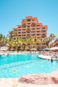 a resort swimming pool with a hotel in the background at Costa de Oro Beach Hotel in Mazatl&aacute;n