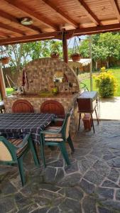 um pátio com uma mesa e cadeiras e um forno de pedra em Къща за гости в селска местност em Petrich