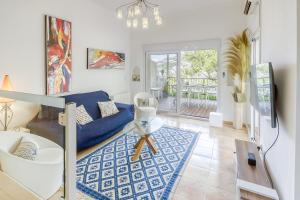 ein Wohnzimmer mit einem blauen Sofa und einem blauen Teppich in der Unterkunft Gauguin 44 Almadrava Roses - Immo Barneda in Roses
