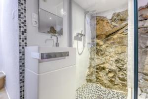 ein Badezimmer mit einem Waschbecken und einer Steinmauer in der Unterkunft Gauguin 44 Almadrava Roses - Immo Barneda in Roses
