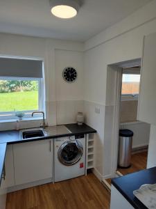 a kitchen with a washing machine and a sink at Jarvis Drive 3 Bed contractor house In melton Mowbray in Melton Mowbray