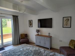 a living room with a flat screen tv on the wall at Jarvis Drive 3 Bed contractor house In melton Mowbray in Melton Mowbray