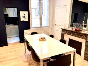 a dining room with a table and a fireplace at Appartement 105 m2 rue Foch Arc de Triomphe hyper centre Montpellier in Montpellier