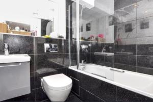 a bathroom with a toilet and a sink and a tub at New Flat (12 mins Central London/Gatwick Airport) in Croydon